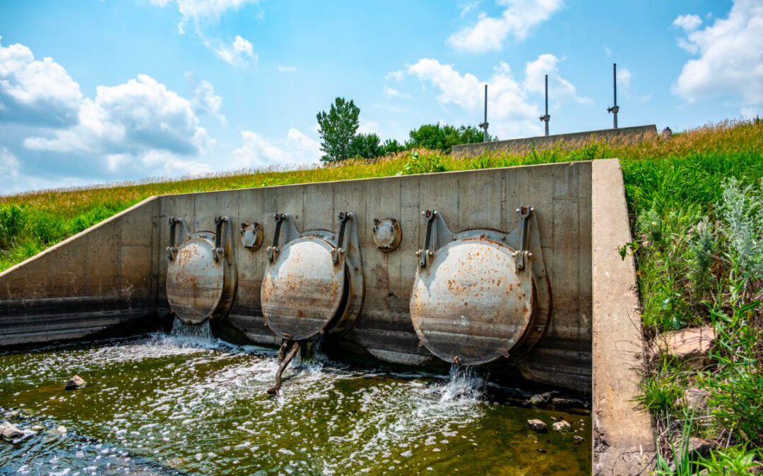 heavy metal flood control gate discharging into a waterbody.